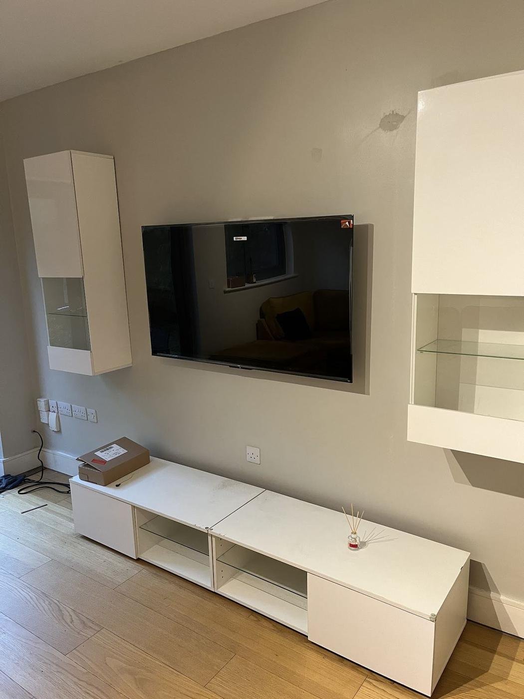 Wall-mounted TV above white floating units, fitted on the visit in CR’s review