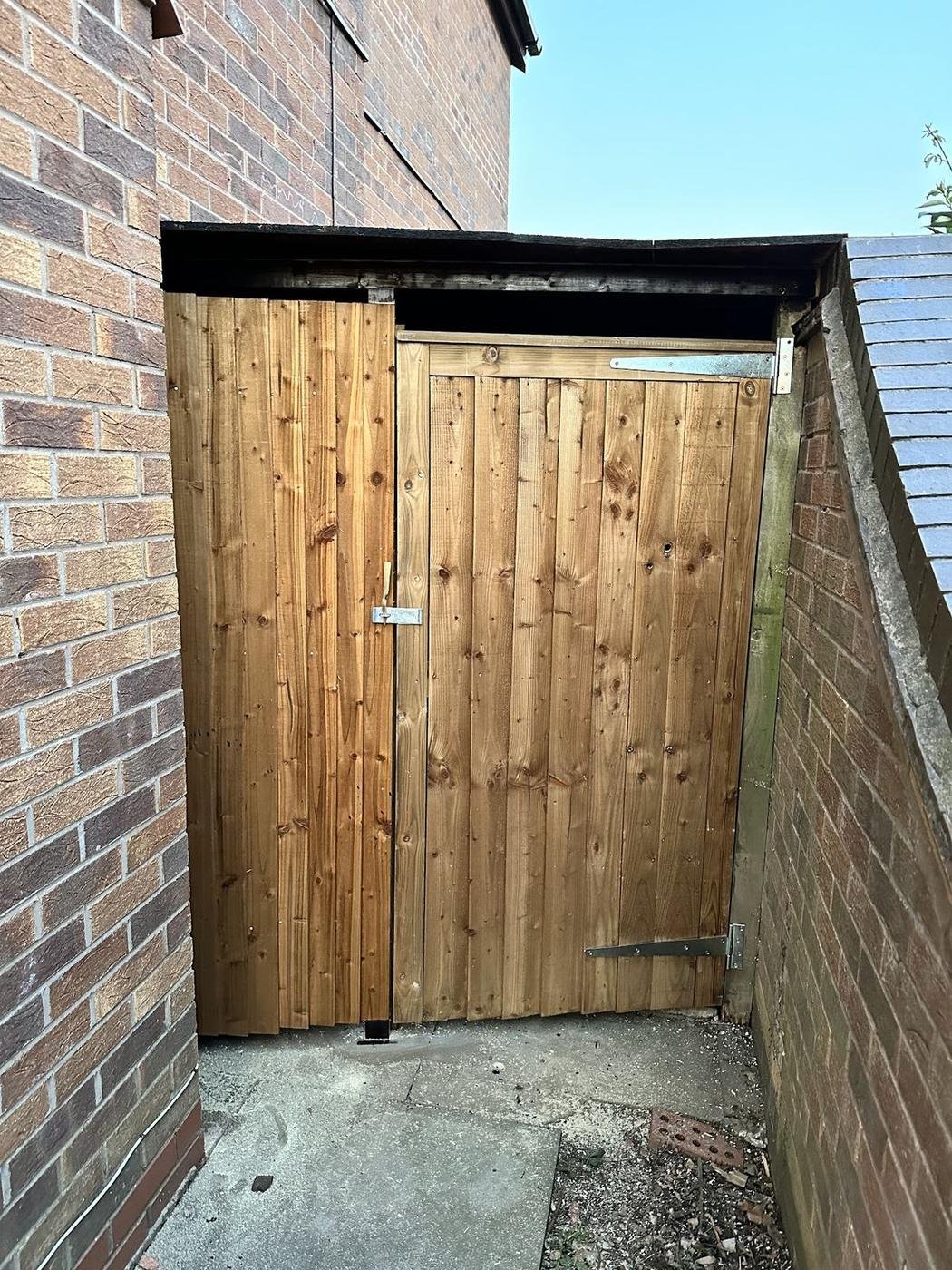 A new timber side gate between two brick walls