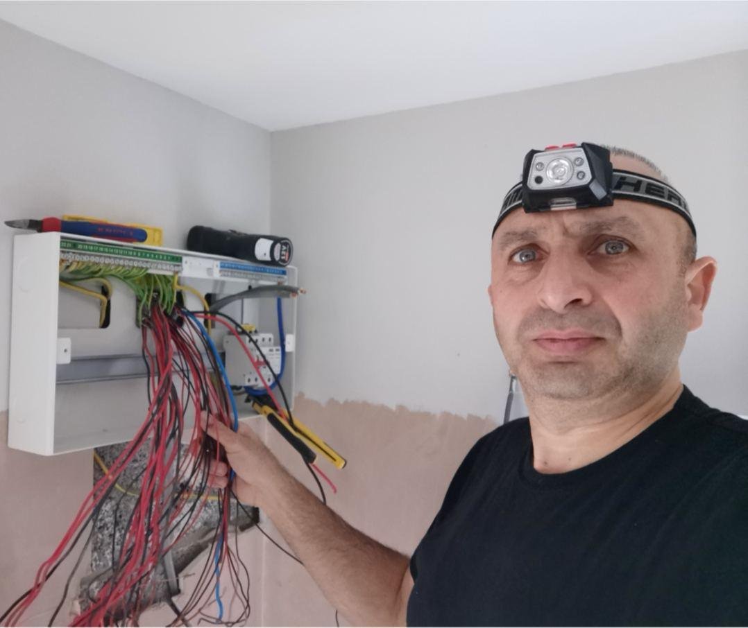 Norman wiring a consumer unit, head torch on